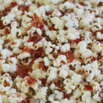 A plate of popcorn with toppings on it.