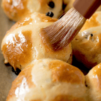 Brushing the tops of hot cross buns