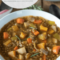 A white bowl filled with lentil soup and colorful vegetables