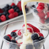 Strawberries, raspberries and blueberries getting coated with hot custard